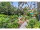 Lush backyard garden with stone pathways, seating areas, and colorful plants, creating a serene outdoor space at 1315 E 24Th St, Sanford, FL 32771