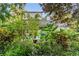 View of a spacious backyard patio with seating area, surrounded by vibrant landscaping and mature trees at 1315 E 24Th St, Sanford, FL 32771