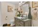 Charming bathroom with a decorative mirror, vanity, fresh flowers, and a classic toilet at 1315 E 24Th St, Sanford, FL 32771