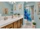 Bright bathroom with white countertop, wooden cabinets, and tub with blue floral shower curtain at 1315 E 24Th St, Sanford, FL 32771