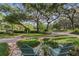 Charming front yard with manicured lawn, stone pathways, and cozy seating under mature trees at 1315 E 24Th St, Sanford, FL 32771