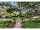 Well-manicured front yard with stone pathway, lush landscaping, and mature trees, creating a welcoming entrance at 1315 E 24Th St, Sanford, FL 32771