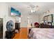 Bedroom showing wood floors, light walls, and a ceiling fan and mounted tv at 1321 Dunbarton Ct, Kissimmee, FL 34758