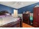 Bedroom with a dark-blue accent wall, ceiling fan, and warm laminate floors at 1321 Dunbarton Ct, Kissimmee, FL 34758