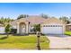 Charming single-story home with a well-manicured lawn, two-car garage, and inviting front entrance at 1321 Dunbarton Ct, Kissimmee, FL 34758
