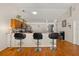 Modern kitchen featuring a breakfast bar with three stools and wood laminate flooring at 1321 Dunbarton Ct, Kissimmee, FL 34758