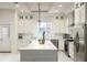 Bright kitchen with a white island, stainless steel appliances, and tile backsplash extending to the ceiling at 141 S. Park Ave, Winter Garden, FL 34787
