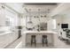 Modern, all-white kitchen with a large island, stainless steel appliances, and stylish pendant lighting at 141 S. Park Ave, Winter Garden, FL 34787