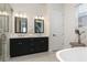 Elegant bathroom with dual vanities, sleek cabinets, and a soaking tub for a relaxing experience at 141 S. Park Ave, Winter Garden, FL 34787
