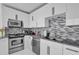 Close up of a modern kitchen featuring stainless steel appliances and a decorative tile backsplash at 150 E Robinson St # 2111, Orlando, FL 32801