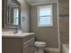 Bathroom featuring modern vanity with gray wall paint and blue tile trim at 1516 Culverhouse Dr, Daytona Beach, FL 32117