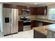Kitchen with stainless steel appliances, granite counters and dark wood cabinets at 1516 Culverhouse Dr, Daytona Beach, FL 32117