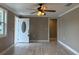 Living room featuring a ceiling fan, front door and wood-look floors at 1516 Culverhouse Dr, Daytona Beach, FL 32117