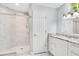 Bathroom featuring marble-patterned shower, granite countertop vanity with white cabinets, and ample lighting at 1525 Farrindon Cir, Lake Mary, FL 32746