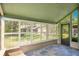 Cozy screened patio with shutter windows, slate tile flooring, and an entry door at 1525 Farrindon Cir, Lake Mary, FL 32746