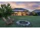 Relaxing backyard featuring a fire pit and chairs, with a covered patio and lush lawn at 16086 Johns Lake Overlook Dr, Winter Garden, FL 34787