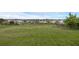 Large backyard with a fire pit and lake views beyond the fence at 16086 Johns Lake Overlook Dr, Winter Garden, FL 34787