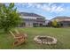 Expansive backyard featuring a fire pit and Adirondack chairs perfect for outdoor entertaining at 16086 Johns Lake Overlook Dr, Winter Garden, FL 34787