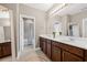 Bright bathroom with double sinks, white countertops, and tiled shower at 16086 Johns Lake Overlook Dr, Winter Garden, FL 34787