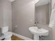 Powder room features a pedestal sink, mirror and modern fixtures at 16086 Johns Lake Overlook Dr, Winter Garden, FL 34787