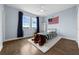 Comfortable bedroom with hardwood floors, a ceiling fan, two windows and an american flag at 16086 Johns Lake Overlook Dr, Winter Garden, FL 34787