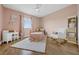 This bedroom features light pink walls, wood floors, white furniture, and a large window with natural light at 16086 Johns Lake Overlook Dr, Winter Garden, FL 34787