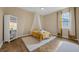 Cozy bedroom with wood floors, canopy bed and soft natural light at 16086 Johns Lake Overlook Dr, Winter Garden, FL 34787