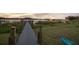 View of the dock with solar lights leading to boat houses on the lake at 16086 Johns Lake Overlook Dr, Winter Garden, FL 34787