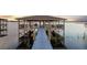 Covered boat dock on the water, with boat lift, seating area, and walkway at 16086 Johns Lake Overlook Dr, Winter Garden, FL 34787