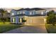 Two-story home featuring a driveway, lawn and a three-car garage at 16086 Johns Lake Overlook Dr, Winter Garden, FL 34787