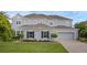Charming two-story home with a manicured lawn, tasteful landscaping, and a paved driveway at 16086 Johns Lake Overlook Dr, Winter Garden, FL 34787