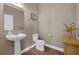 Charming half bathroom with modern fixtures, pedestal sink, and wood-look floors at 16086 Johns Lake Overlook Dr, Winter Garden, FL 34787