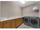 Functional laundry room with a washing machine, dryer, sink and overhead shelving at 16086 Johns Lake Overlook Dr, Winter Garden, FL 34787