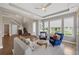 Comfortable living room featuring bright windows, sofa and accent chairs, and wood floors at 16086 Johns Lake Overlook Dr, Winter Garden, FL 34787