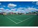 Well-maintained tennis courts ready for play, set against a backdrop of community homes and clear skies at 16086 Johns Lake Overlook Dr, Winter Garden, FL 34787