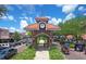 Charming Winter Garden entrance featuring brick architecture, clock tower, and lush landscaping, inviting exploration and enjoyment at 16086 Johns Lake Overlook Dr, Winter Garden, FL 34787
