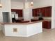 Bright, open-concept kitchen features stainless appliances, dark wood cabinets, and breakfast bar seating at 2143 Autumn View Dr, Orlando, FL 32825