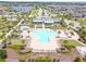 Community pool in a cross shape with palm trees and landscaping, surrounded by neighborhood at 2227 Blue Salvia St, Clermont, FL 34711