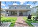 An inviting backyard with manicured grass, brick pathway and covered patio with a built in grill at 2227 Blue Salvia St, Clermont, FL 34711