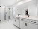 Bright bathroom featuring double vanity sinks, modern fixtures and a glass enclosed shower at 2227 Blue Salvia St, Clermont, FL 34711