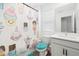 Charming bathroom with colorful cupcake shower curtain, a modern vanity, and a turquoise toilet seat at 2227 Blue Salvia St, Clermont, FL 34711