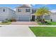 Charming two-story home with a brick driveway, two-car garage and well-manicured lawn, enhanced with a palm tree at 2227 Blue Salvia St, Clermont, FL 34711