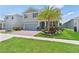 Attractive two-story home featuring a brick driveway, two-car garage, lush lawn and palm tree at 2227 Blue Salvia St, Clermont, FL 34711