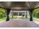 Backyard gazebo with brick patio, curtains, and palm trees at 2227 Blue Salvia St, Clermont, FL 34711