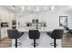 Modern kitchen with white cabinets, quartz countertops and an island with barstool seating at 2227 Blue Salvia St, Clermont, FL 34711