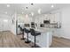 Bright, modern kitchen with white cabinets, quartz countertops, stainless appliances, and island with barstool seating at 2227 Blue Salvia St, Clermont, FL 34711