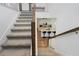 Carpeted staircase with white railings and wood banister leads to a view of the kitchen at 2227 Blue Salvia St, Clermont, FL 34711