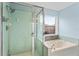 Well-lit bathroom has a glass shower, soaking tub and accent tilework around the base at 2311 Alton Rd, Deltona, FL 32738
