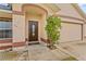 Close-up of the home's front entrance, accented by a brown door and manicured shrubbery at 2311 Alton Rd, Deltona, FL 32738