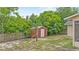 Backyard shot of the storage shed behind the house with grass, a fence, and some trees at 2311 Alton Rd, Deltona, FL 32738
